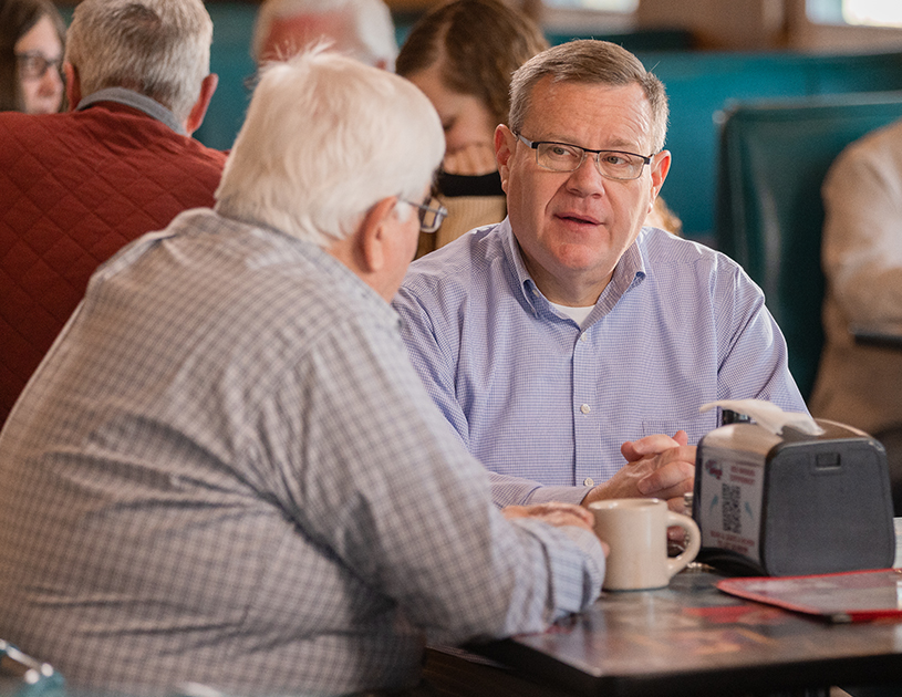 Tim Moore speaking with someone at a restaurant